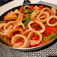Calamari in a spicy tomato sauce with green peppers and spanish sausagein a spicy tomato sauce with green peppers