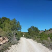 A dirt track through the Spanish mountains with beautiful, cloudless blue skies